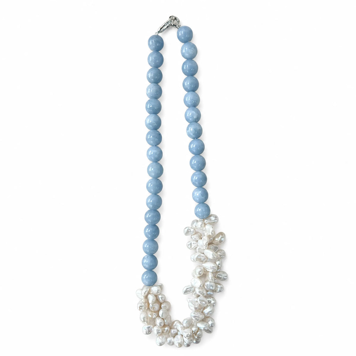 Angelite beaded necklace with a cluster of white petal-shaped baroque pearls, flat lay on white background