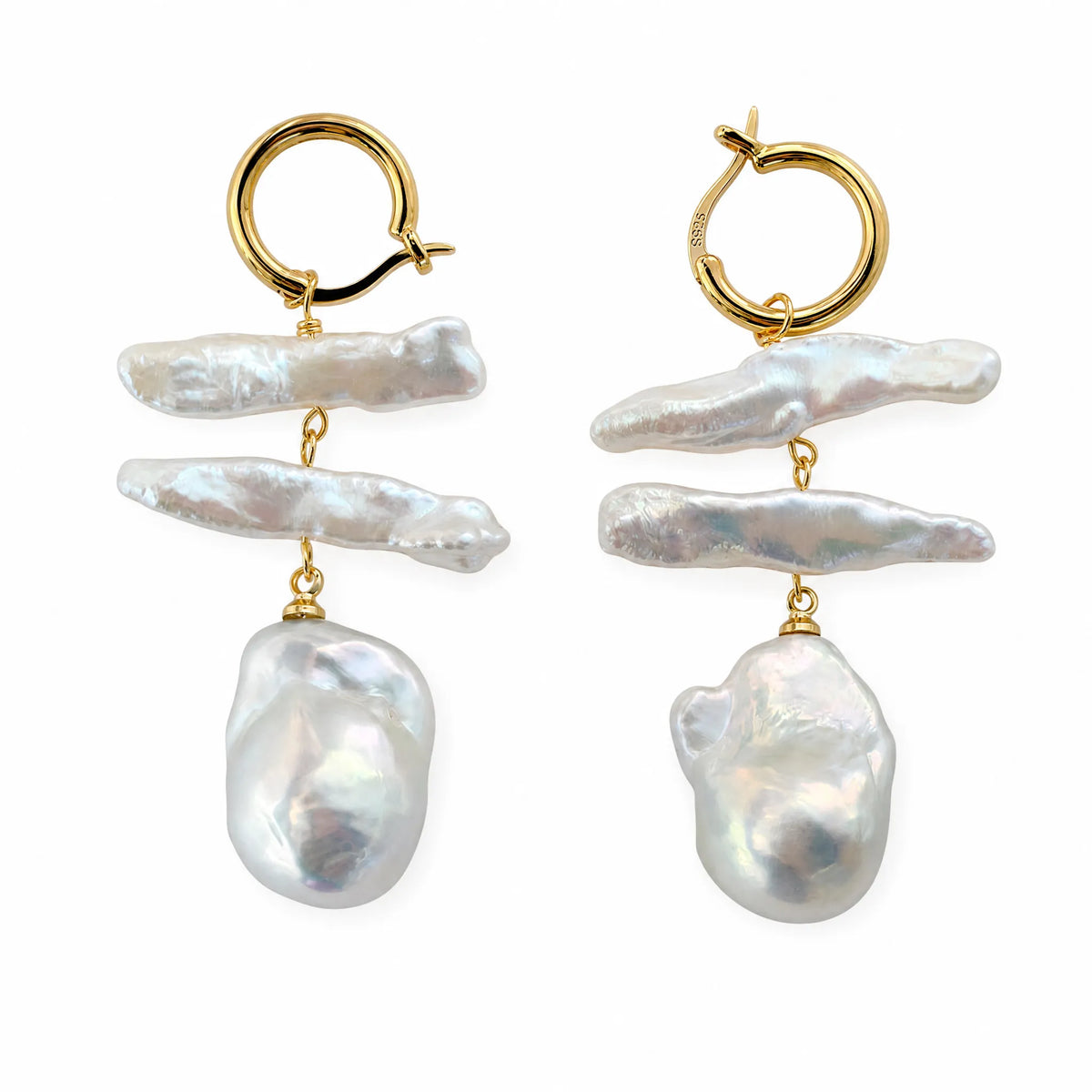 Pair of layered baroque pearl drop earrings with gold ear hooks, flat lay on white background