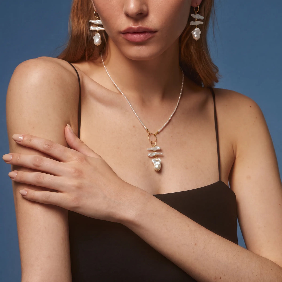 Woman wearing a pearl chain necklace with detachable layered baroque pearl pendant