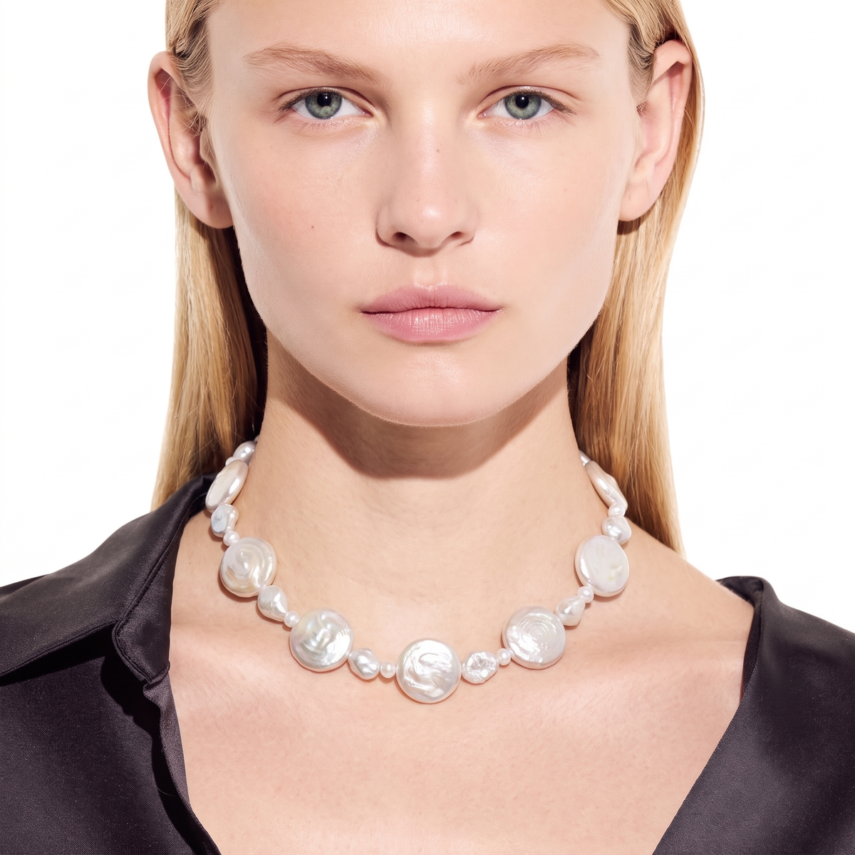 Front view of a woman wearing a graduated white pearl necklace centered on a white background