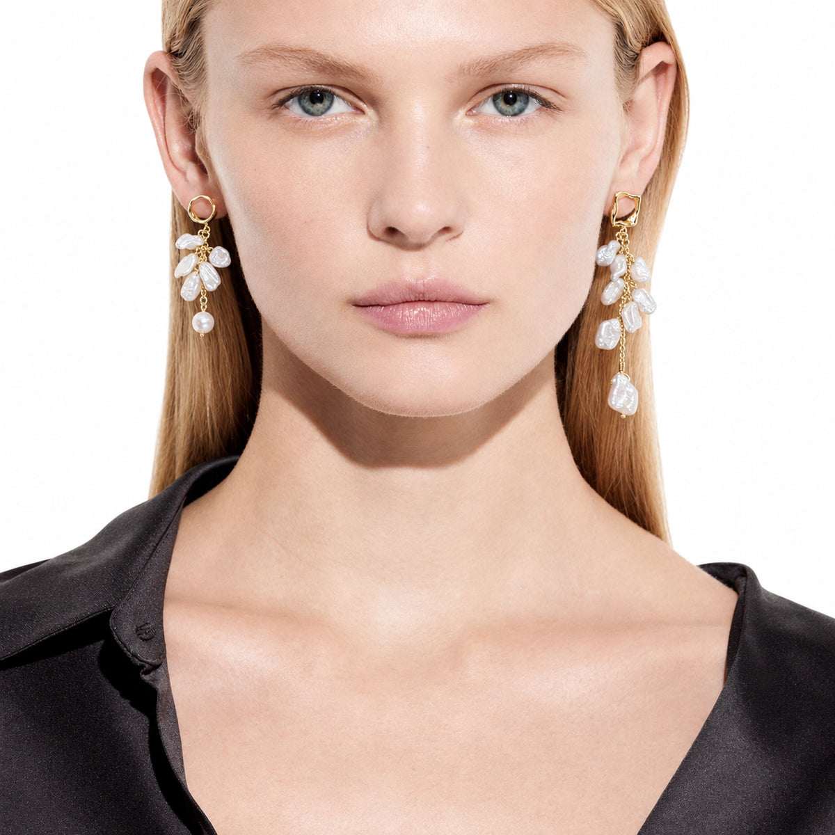 Woman wearing matching petal cluster keshi pearl earrings on both ears, front view