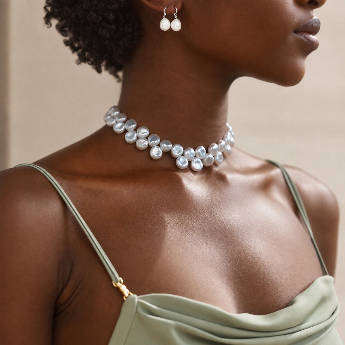 Woman wearing a silver baroque pearl choker necklace with matching pearl drop earring